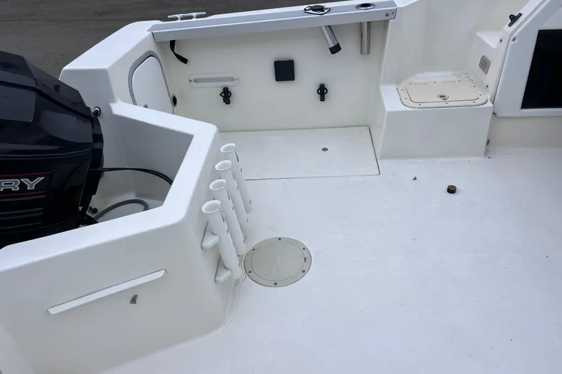 Slide: The Image of 1993 Bayliner Trophy Walkaround boat deck with Mercury engine and rod holders. - 14