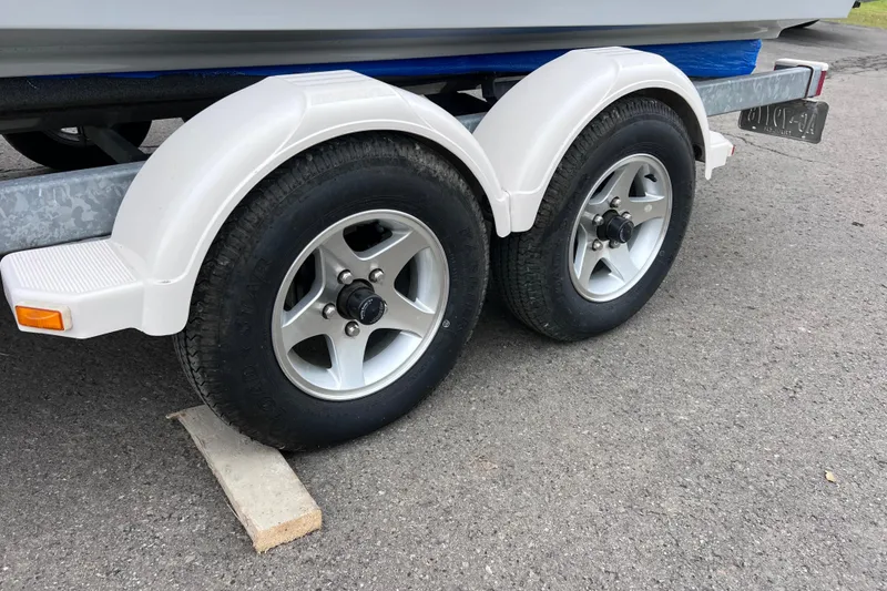 Slide: The Image of Trailer wheels of a 1993 Bayliner Trophy Walkaround boat on pavement. - 3