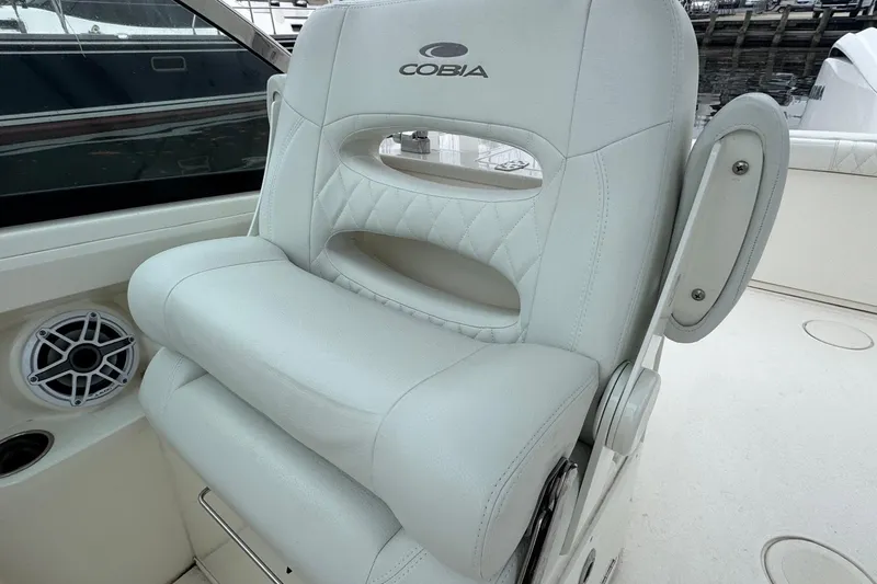 Slide: The Image of 2024 Cobia 240 Dual Console boat seat with speaker and cup holder. - 10