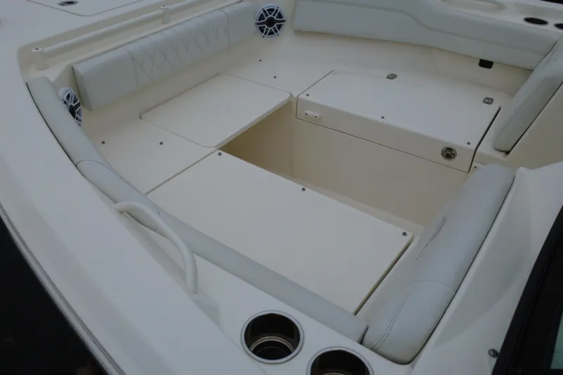 Slide: The Image of 2024 Cobia 240 Dual Console boat interior with cushioned seating and storage compartments. - 15