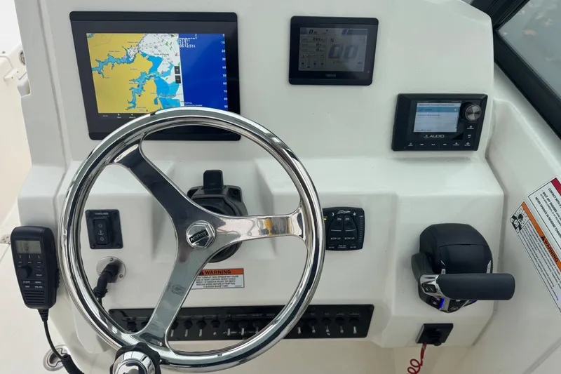 Slide: The Image of 2024 Cobia 240 Dual Console dashboard with steering wheel, navigation, and audio controls. - 8