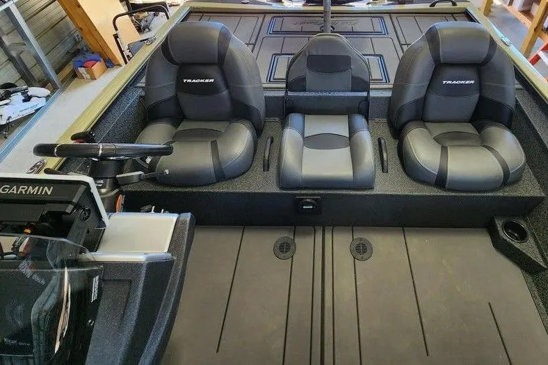 Slide: The Image of 2026 Tracker Savage 215 boat interior with three black seats and Garmin navigation system. - 13