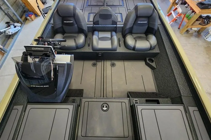 Slide: The Image of 2026 Tracker Savage 215 boat interior with Garmin system and three black seats. - 8