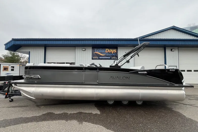 The Image of 2026 Avalon Catalina Versatile Rear Bench pontoon boat parked outside a marine shop. - 1