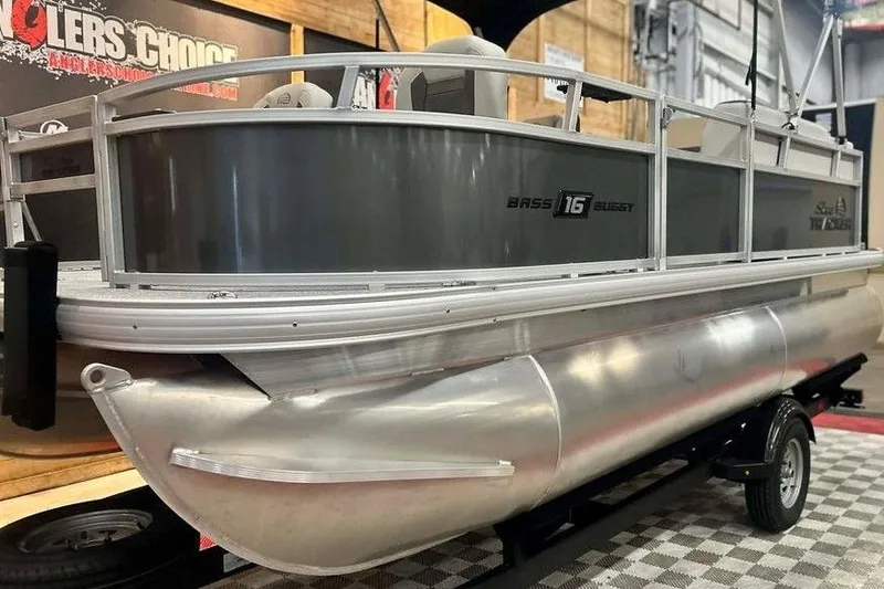 Slide: The Image of 2026 Sun Tracker Bass Buggy 16 XL Select pontoon boat on display indoors. - 13