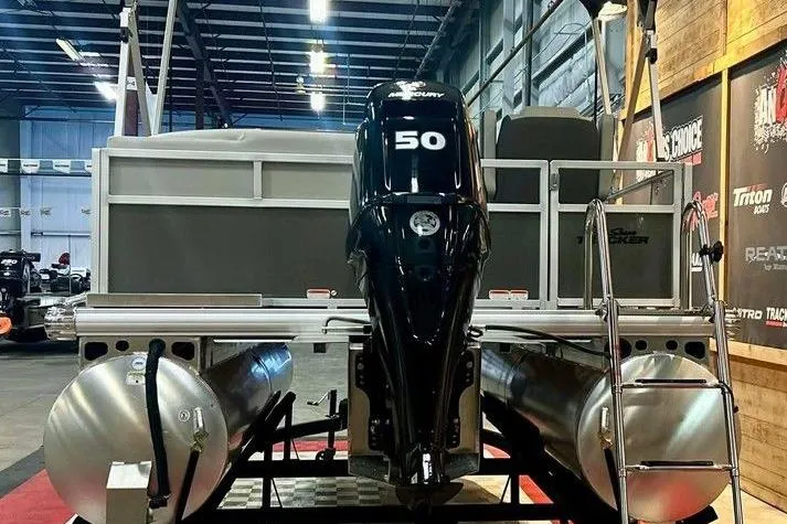 Slide: The Image of 2026 Sun Tracker Bass Buggy 16 XL Select pontoon boat with 50 HP engine in showroom. - 4