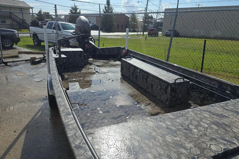 Slide: The Image of 2026 Pro-Drive 1854 boat with camouflage pattern, parked outdoors on a sunny day. - 2