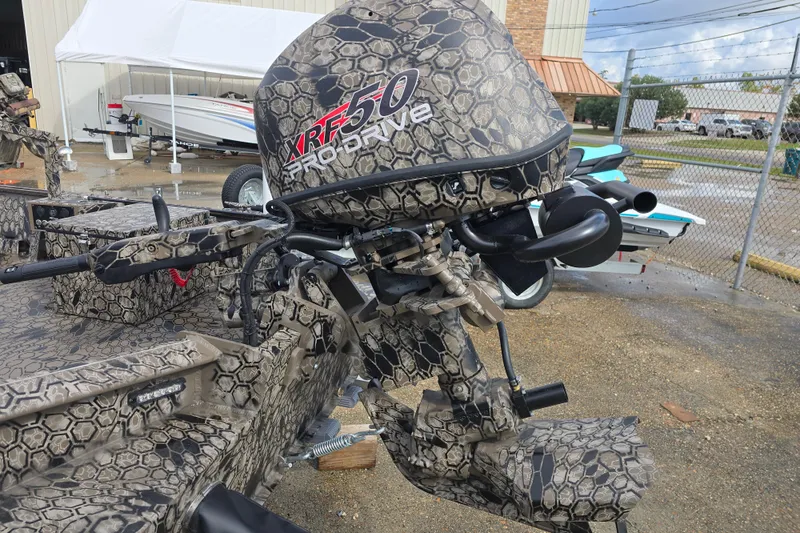 Slide: The Image of Camouflage-patterned 2026 Pro-Drive 1854 boat with XRF50 engine, parked outdoors. - 5