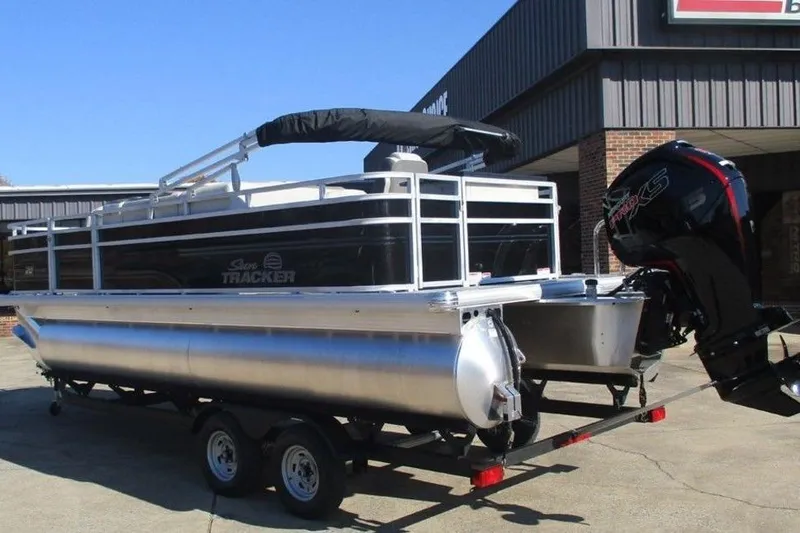 Slide: The Image of 2026 Sun Tracker Fishin' Barge 20 DLX pontoon boat on trailer, outdoor setting. - 10