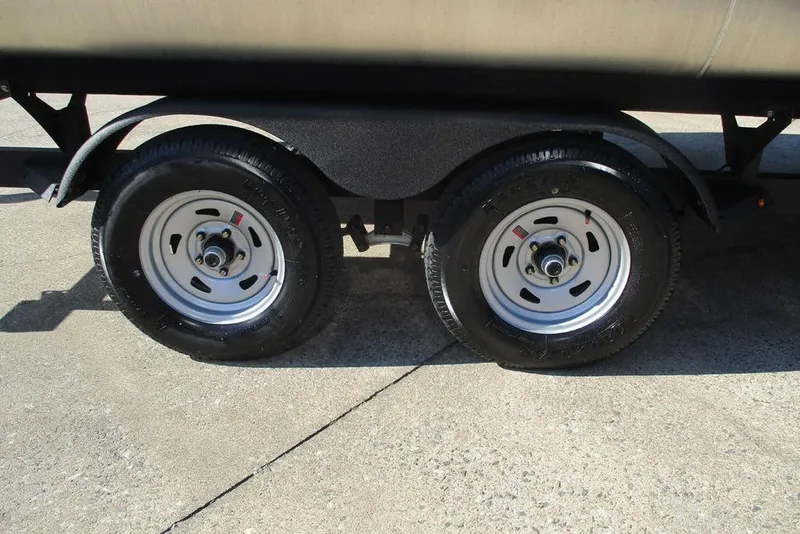 Slide: The Image of Trailer wheels of a 2026 Sun Tracker Fishin' Barge 20 DLX on concrete. - 13