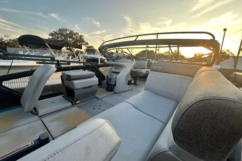 Slide: The Image of 2022 Sea-Doo Switch Sport 21 interior with seating and control panel, docked among other boats. - 15