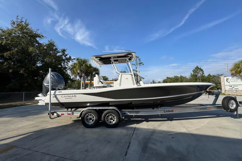 Slide: The Image of 2020 Caymas 28 HB boat on trailer, parked outdoors under clear blue sky. - 11