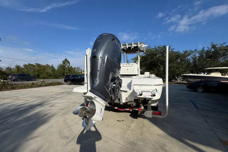 Slide: The Image of 2020 Caymas 28 HB boat with powerful outboard motor in a parking lot. - 15
