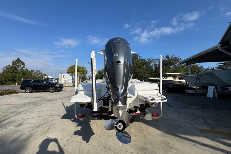 Slide: The Image of 2020 Caymas 28 HB boat with powerful outboard motor in a sunny marina setting. - 16