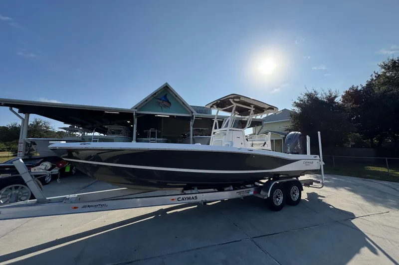 Slide: The Image of 2020 Caymas 28 HB boat on trailer under sunny sky, parked near a building. - 3
