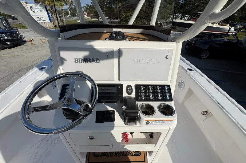 Slide: The Image of 2020 Caymas 28 HB boat console with steering wheel, Simrad displays, and control panel. - 31