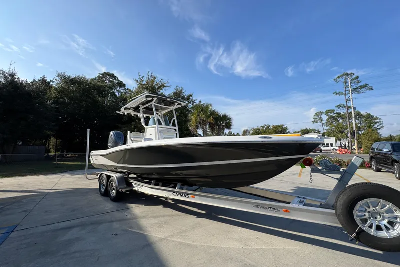 Slide: The Image of 2020 Caymas 28 HB boat on trailer, parked outdoors under clear blue sky. - 9