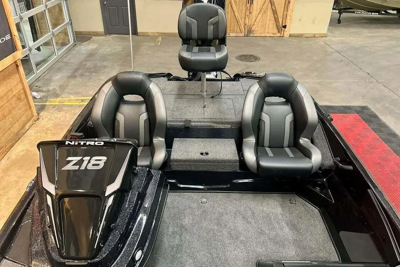 Slide: The Image of 2026 Nitro Z18 Pro boat interior with three black and gray seats in a showroom. - 11