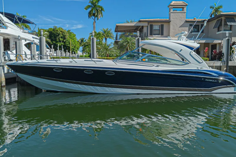 Slide: The Image of 2013 Formula 400 Super Sport boat docked in a sunny marina setting. - 1