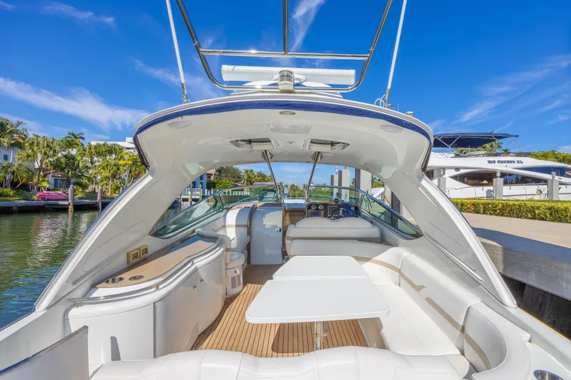 Slide: The Image of 2013 Formula 400 Super Sport yacht interior with sleek seating and table, docked by waterfront homes. - 18