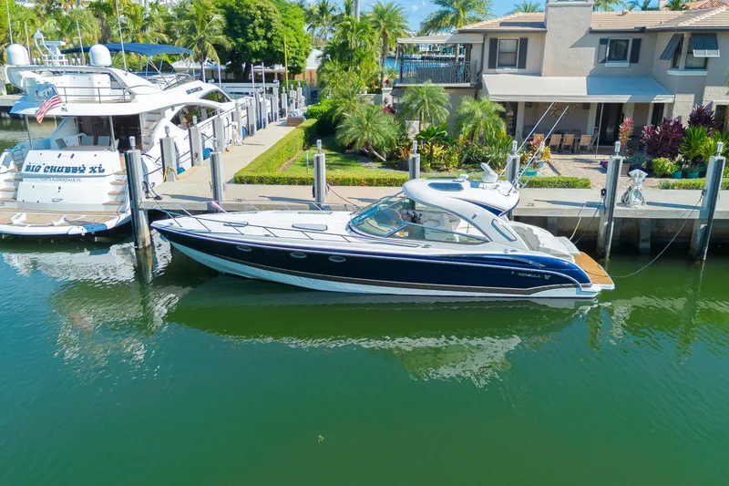 Slide: The Image of 2013 Formula 400 Super Sport yacht docked by waterfront home, surrounded by lush greenery. - 5