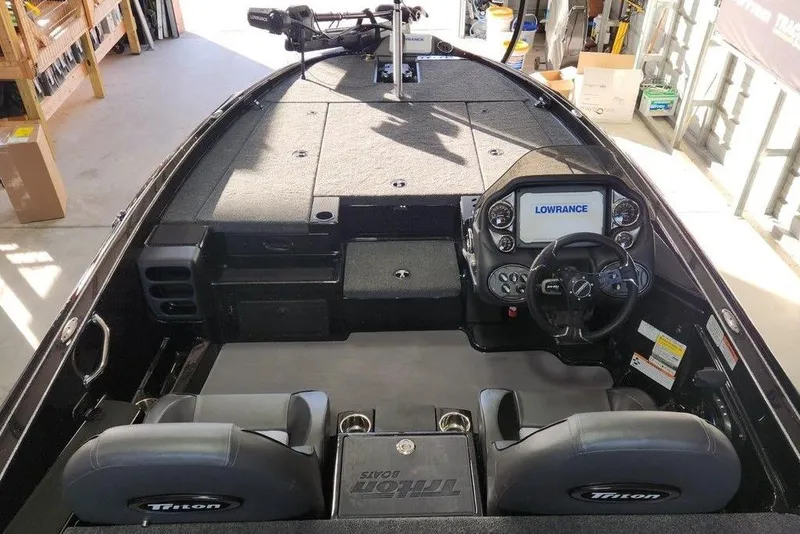 Slide: The Image of 2026 Triton 19 TrX Patriot boat interior with Lowrance navigation system and dual seats. - 2