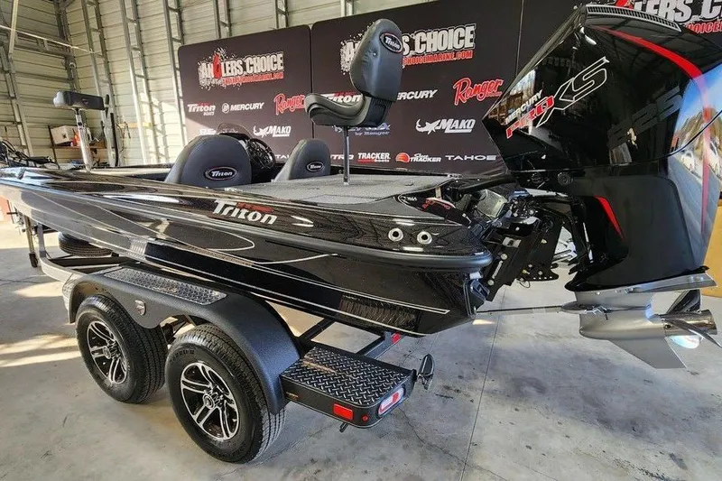 Slide: The Image of 2026 Triton 19 TrX Patriot boat in showroom, featuring sleek black design and powerful engine. - 7