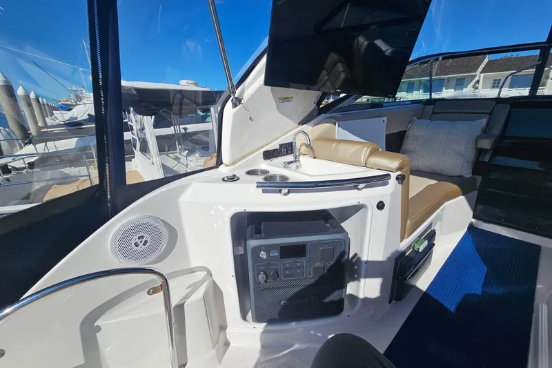 Slide: The Image of Interior of a 2013 Regal 28 Express boat with seating and a small sink. - 12