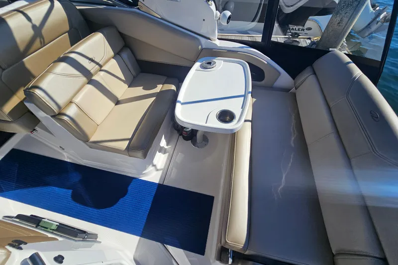Slide: The Image of 2013 Regal 28 Express boat interior with beige seating and a white table. - 14