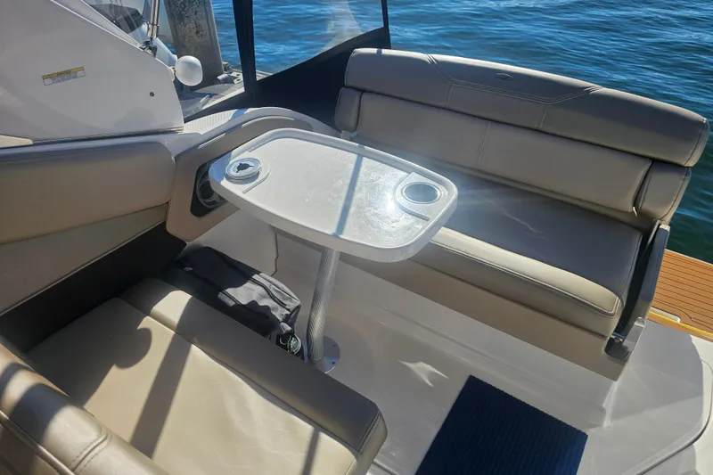 Slide: The Image of 2013 Regal 28 Express boat interior with seating and table, overlooking water. - 15