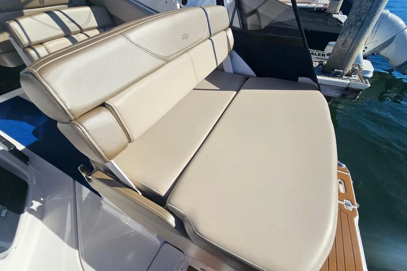 Slide: The Image of 2013 Regal 28 Express boat with beige leather seating, docked by the water. - 16