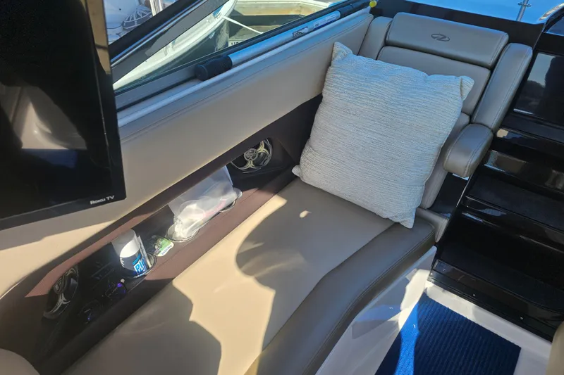 Slide: The Image of Interior of 2013 Regal 28 Express boat with beige seating and pillow. - 18