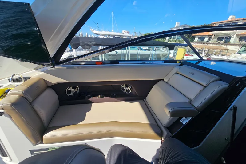Slide: The Image of 2013 Regal 28 Express boat interior with beige seating and open hatch. - 19