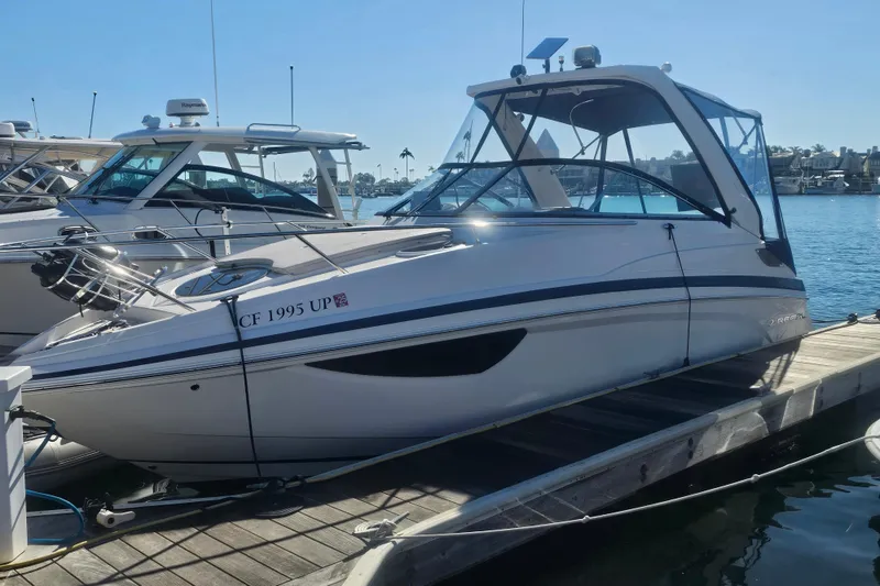 Slide: The Image of 2013 Regal 28 Express boat docked at marina under clear blue sky. - 2
