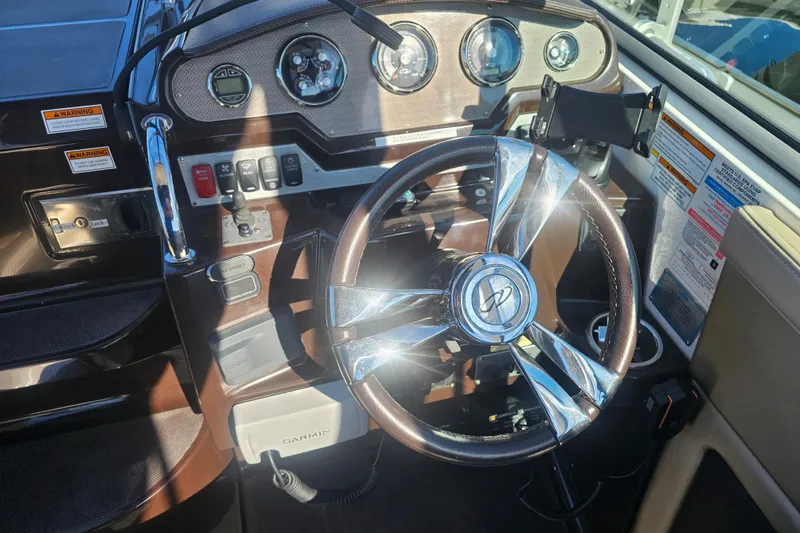 Slide: The Image of 2013 Regal 28 Express boat dashboard with steering wheel and control panel. - 23