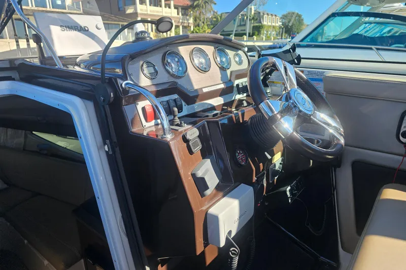 Slide: The Image of 2013 Regal 28 Express boat cockpit with steering wheel and control panel. - 24