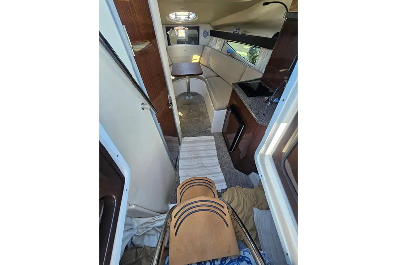 Slide: The Image of Interior of 2013 Regal 28 Express boat with seating, table, and kitchenette. - 25