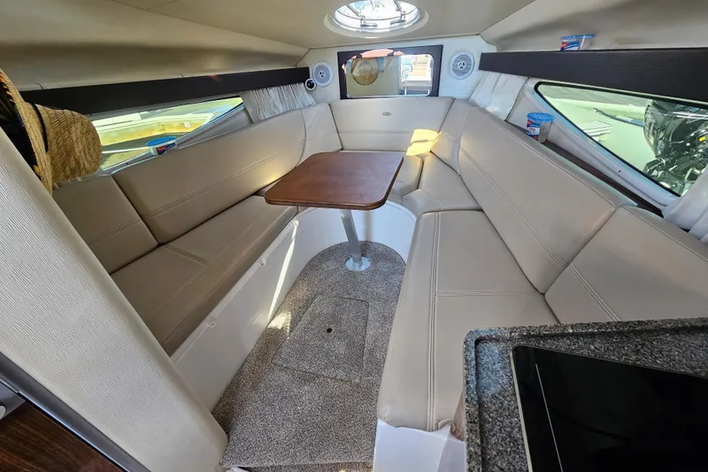Slide: The Image of Interior of 2013 Regal 28 Express boat with beige seating and wooden table. - 26
