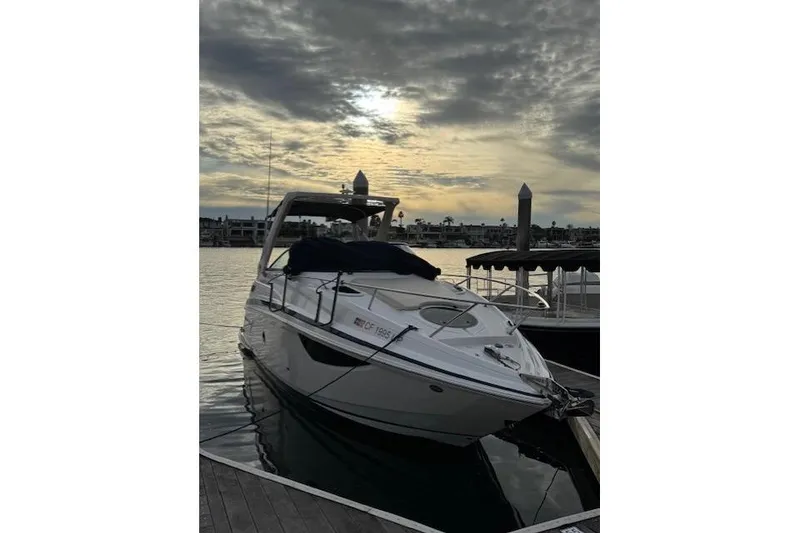 Slide: The Image of 2013 Regal 28 Express boat docked at sunset with cloudy sky. - 3
