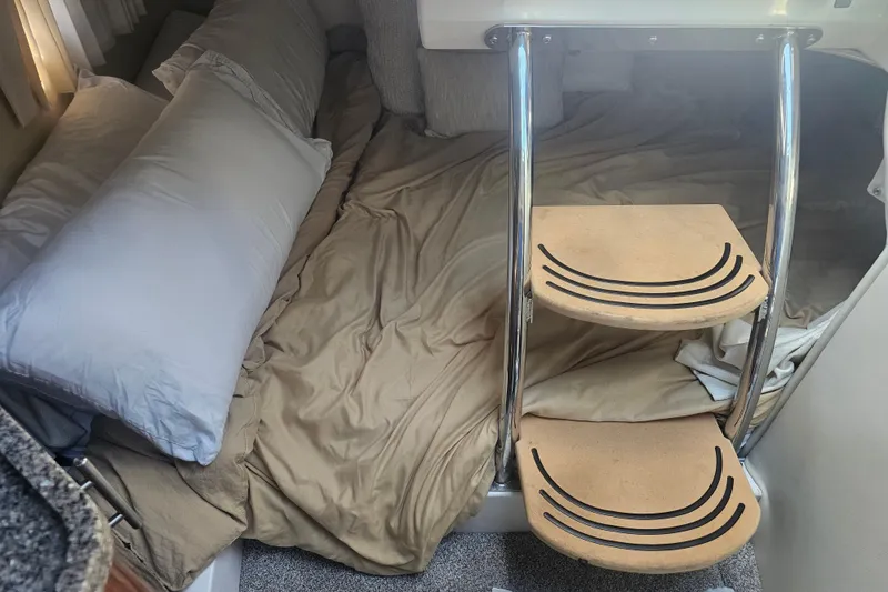 Slide: The Image of 2013 Regal 28 Express cabin interior with bed and wooden steps. - 30