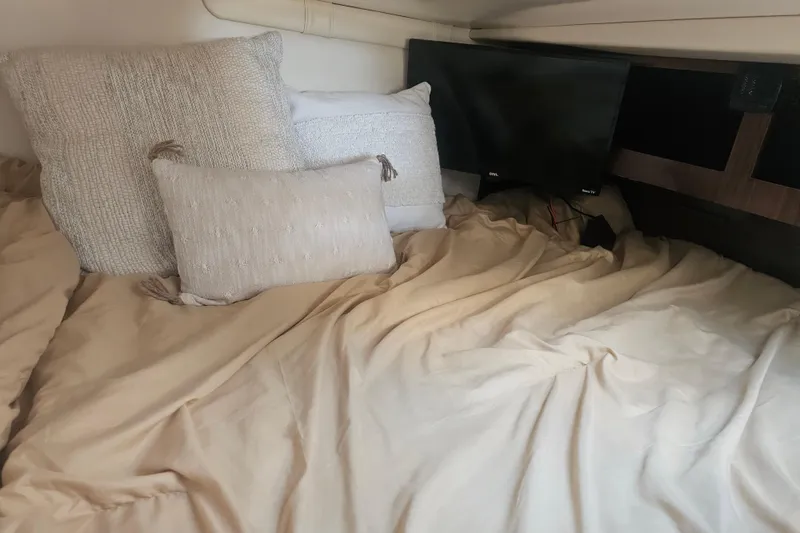 Slide: The Image of Cozy cabin interior of 2013 Regal 28 Express with pillows and a small TV. - 31