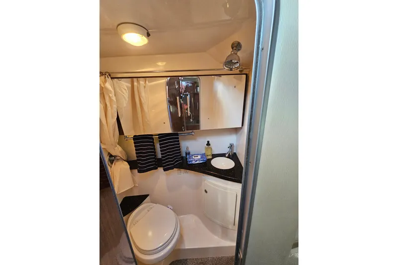 Slide: The Image of Compact bathroom in 2013 Regal 28 Express boat with sink, toilet, and mirror. - 32