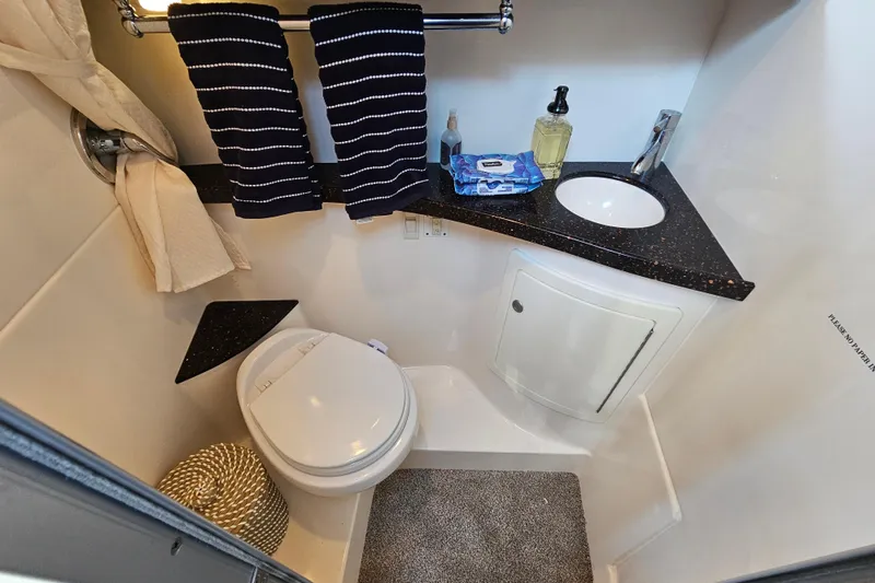 Slide: The Image of Compact bathroom in 2013 Regal 28 Express boat with modern fixtures and striped towels. - 33