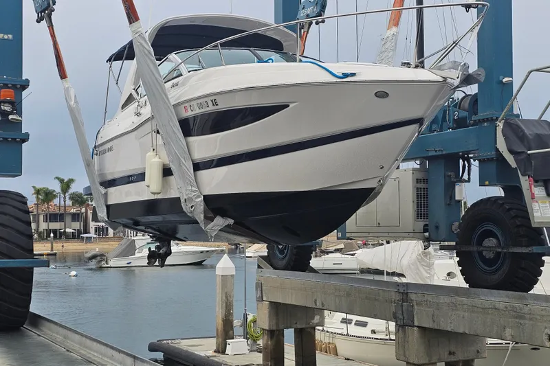 Slide: The Image of 2013 Regal 28 Express boat being lifted at a marina. - 35
