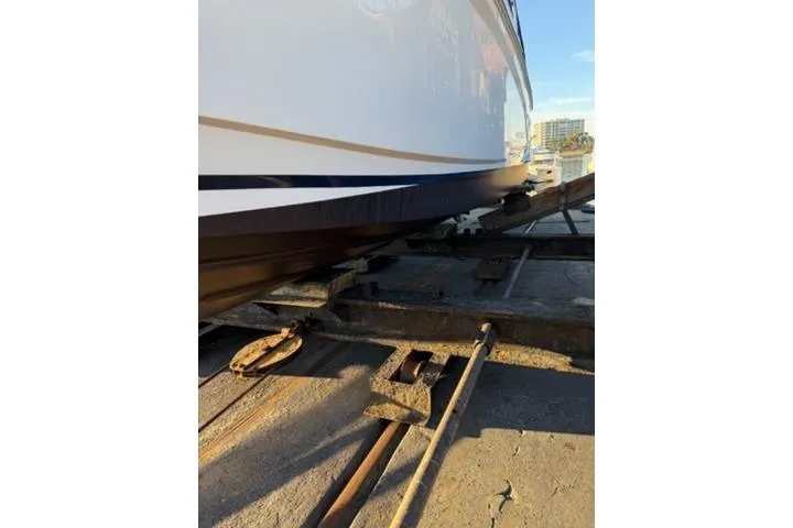 Slide: The Image of 2013 Regal 28 Express boat on dry dock, showcasing hull and rail system. - 36