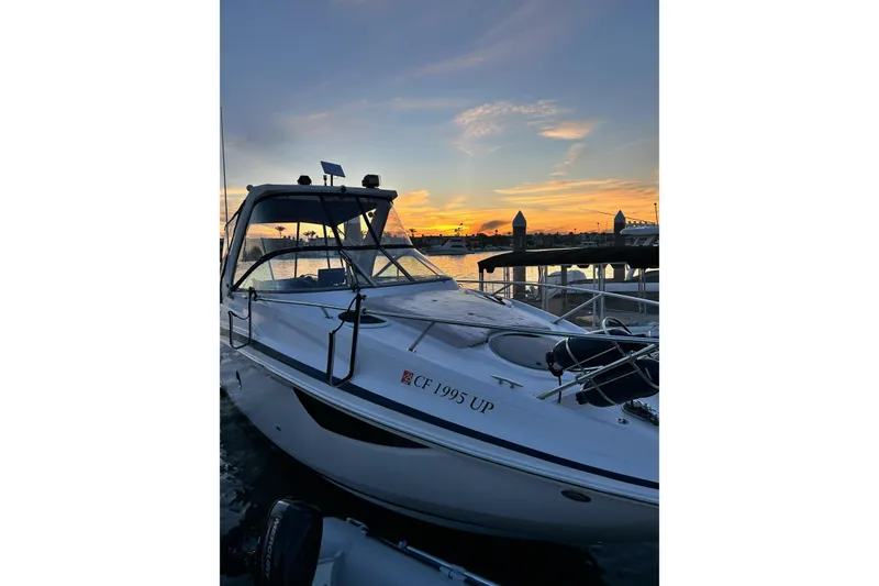 Slide: The Image of 2013 Regal 28 Express boat docked at sunset, with vibrant sky reflections. - 40