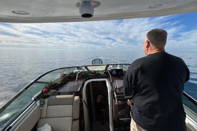 Slide: The Image of Man steering 2013 Regal 28 Express boat on calm sea under blue sky. - 5