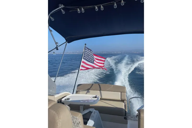 Slide: The Image of 2013 Regal 28 Express boat cruising with American flag, ocean view. - 6