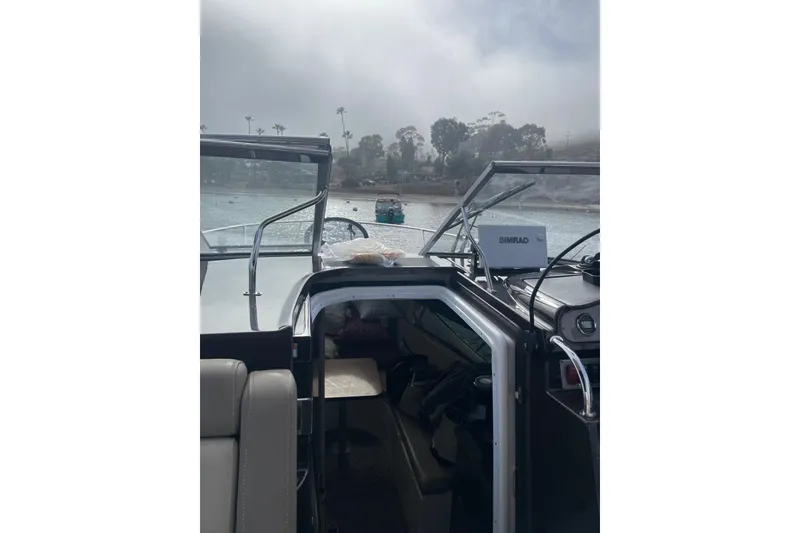 Slide: The Image of 2013 Regal 28 Express boat interior with open cabin door, on a misty waterway. - 7