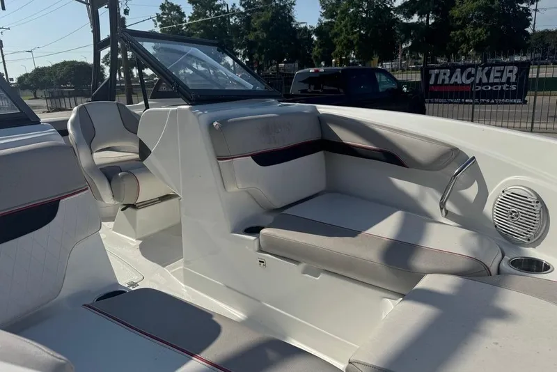 Slide: The Image of 2018 Tahoe 700 TF boat interior with seating and cup holder, parked outdoors. - 13